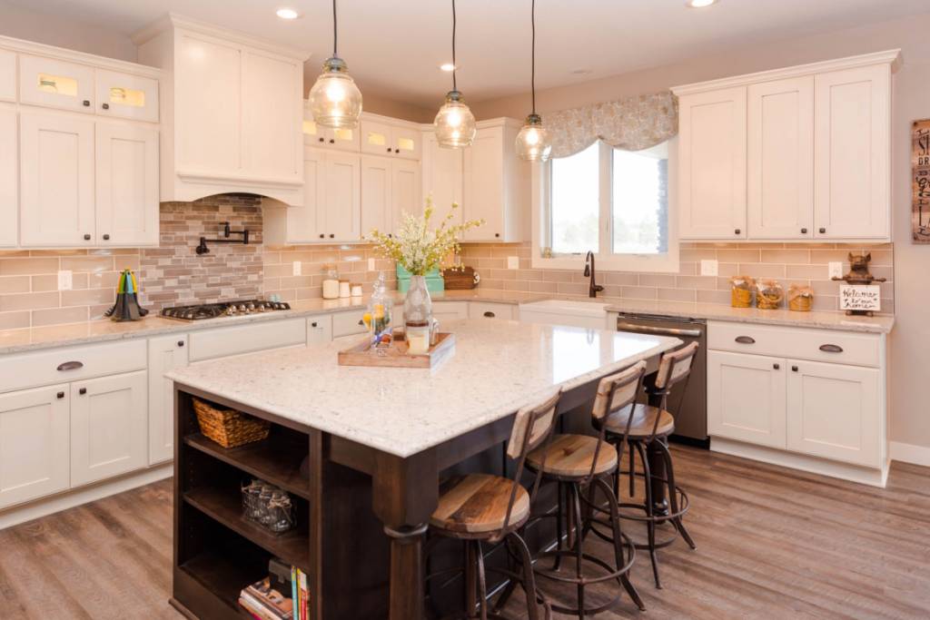 Traditional style kitchen with white perimeter cabinets and dark wood center island