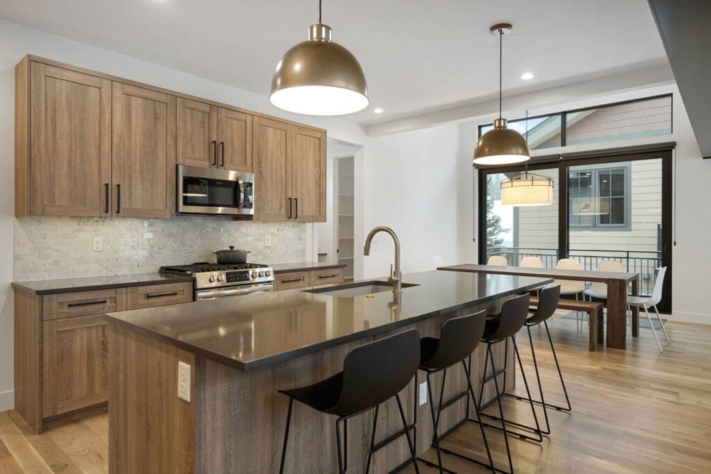 Kitchen with alder wood cabinets and gold pendant lights