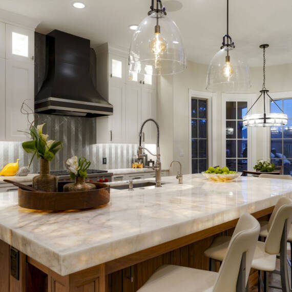 Remodeled kitchen with white Shaker cabinets and underlit countertops