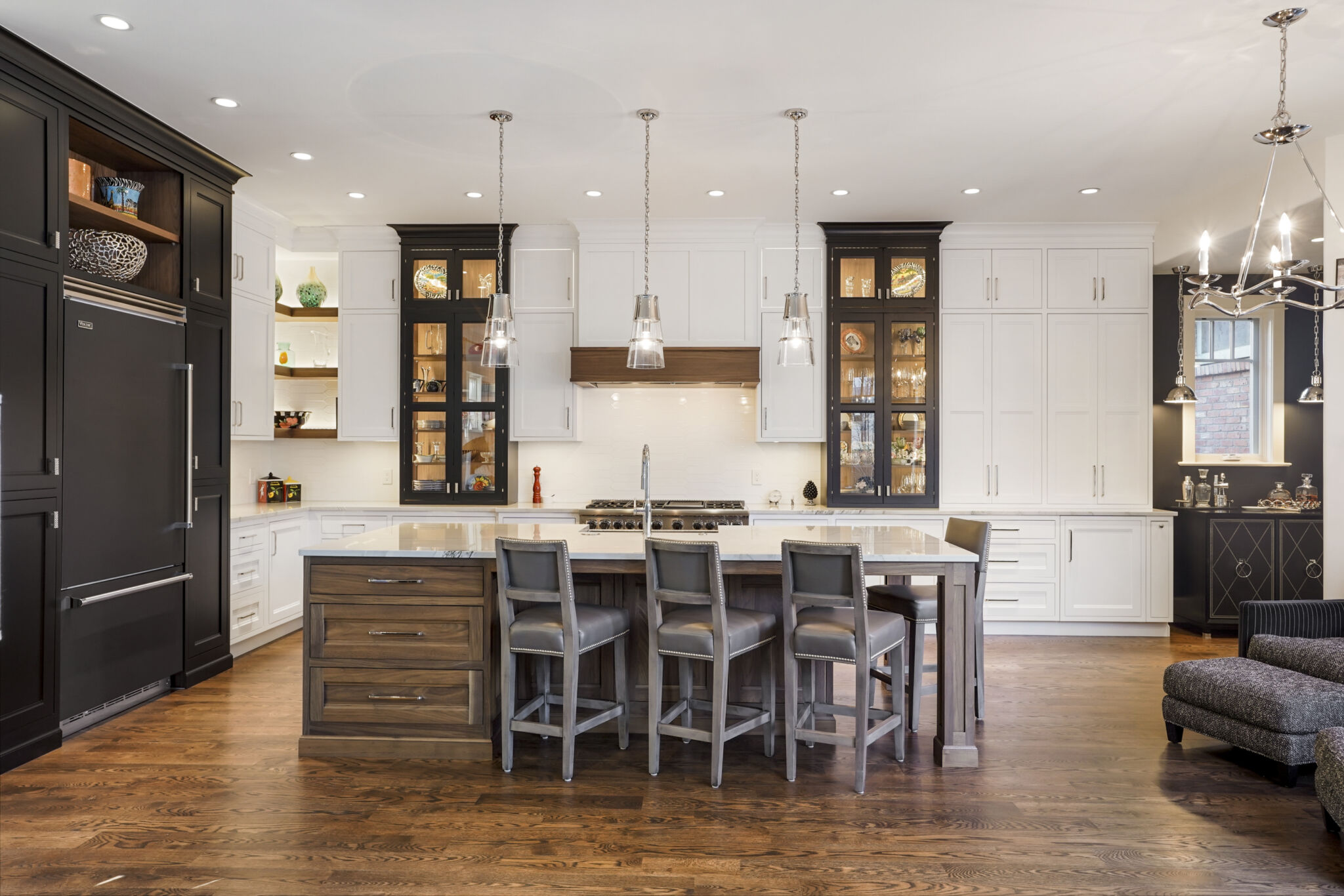 Traditional kitchen with white, black and walnut cabinets and large center island