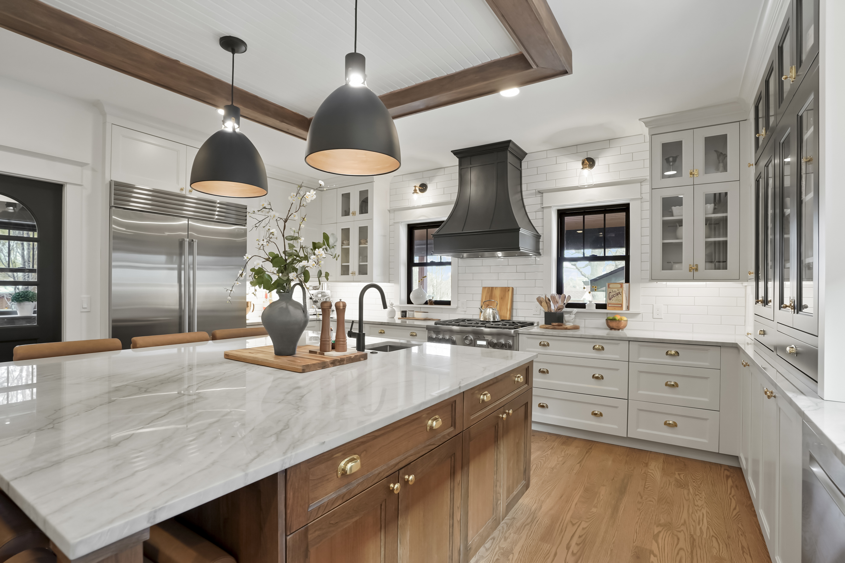 Kitchen with white inset cabinets and walnut island